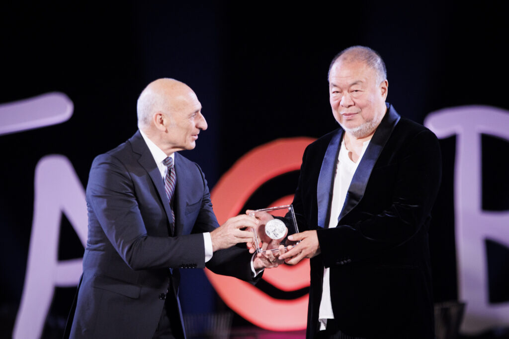 Il direttore del Parco Archeologico Naxos Taormina, Orazio Micali, consegna il Taobuk Award all’artista cinese Ai Weiwei durante la cerimonia al Teatro Antico di Taormina